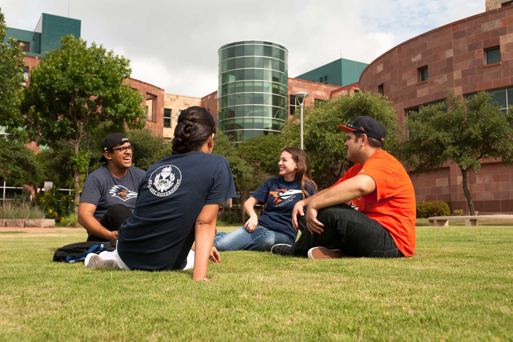 A smiling family walking through a university campus quad.